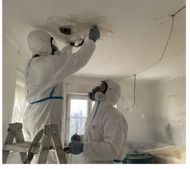 Schadstoffsanierung — Arbeit im Schutzanzug an der Decke